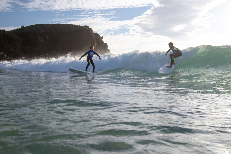Un seul surfeur engagé sur la vague pendant que les autres laissent la priorité