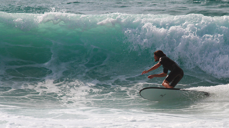 Surfeur fléchi sur sa planche en mousse pendant l’appui sur le rail