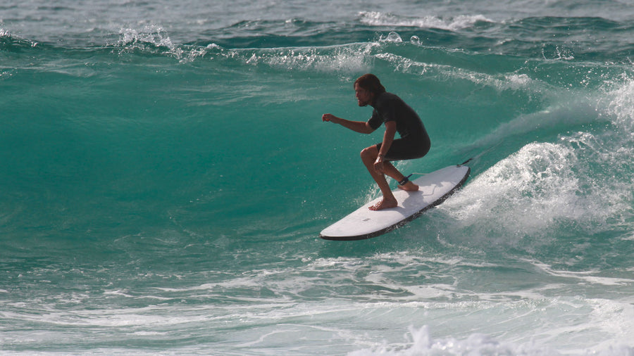 Surfeur partant en angle dès le take-off sur une planche en mousse