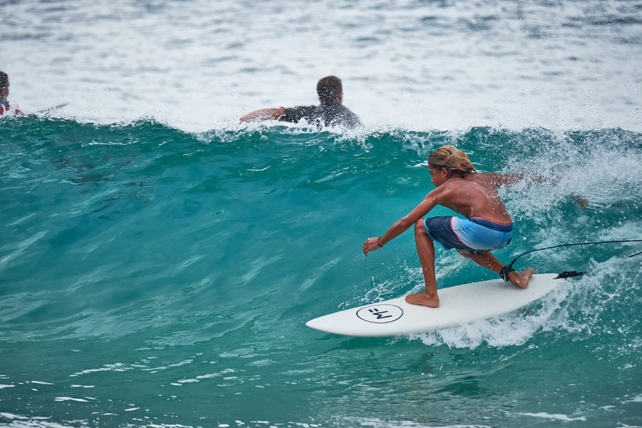 Surfeur face à la vague en position frontside sur un softboard