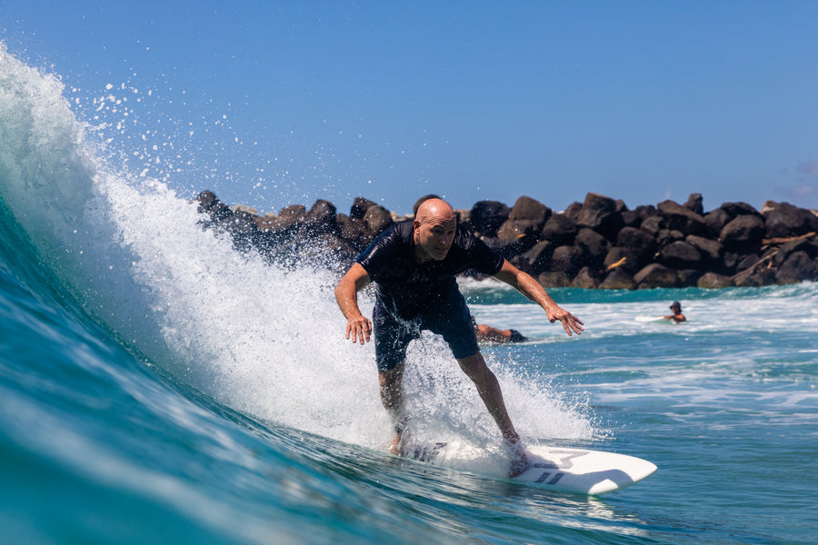 Surfeur engageant un virage en bas de la face d’une petite vague