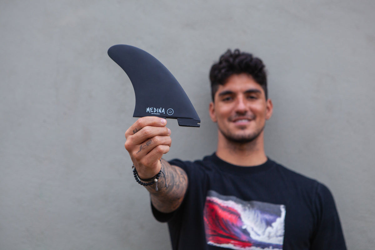 A set of surfboard fins laid out side by side