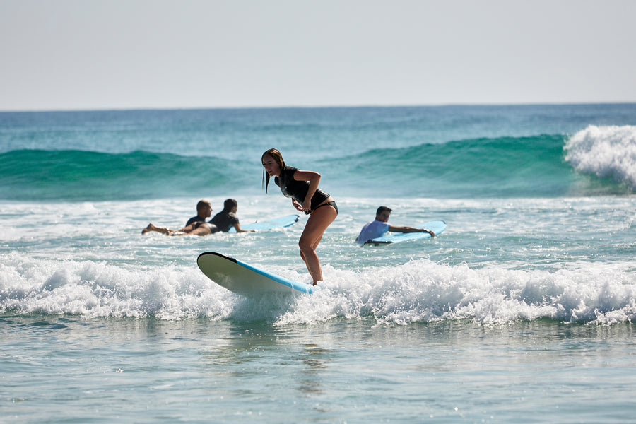 Surfeur debout dans l’eau là où la vague se transforme en mousse