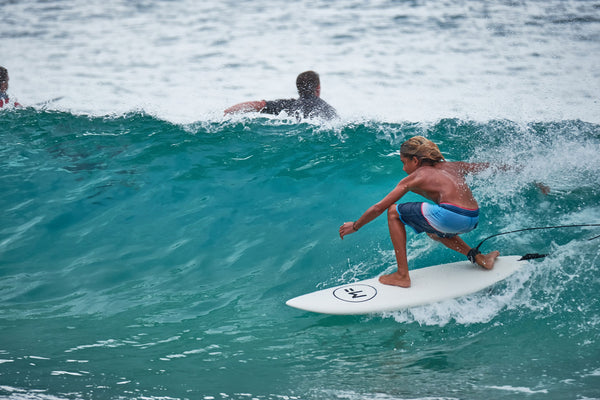 Planche de surf en mousse posée sur le sable